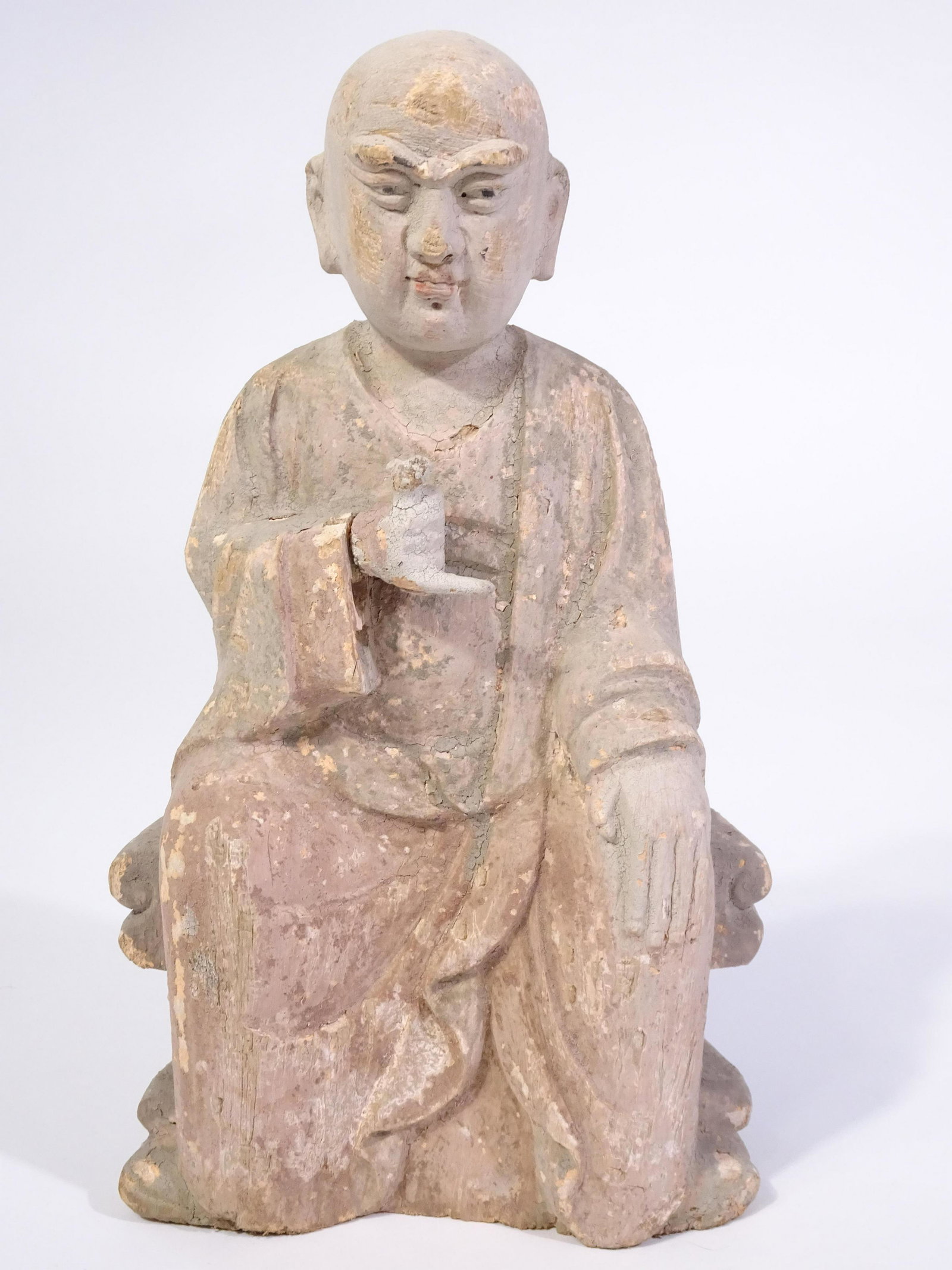 Asian Hand-Carved Monk or Scholar, Circa 1800's: This is an Asian hand-carved wooden monk or scholar, probably done in the 1800's. The figure has a hand on one knee and is holding what appears to be a bag in the other hand. There is an export seal o