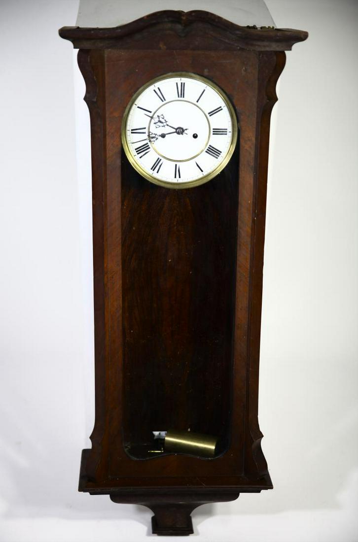Late 1800’s Weight-Driven Wall Clock: This is a tall ornate weight-driven wall clock from the late 1800’s or early 1900’s. It has Roman numerals on the clock face, two narrow glass side panels, a simple bonnet, and two side latches to