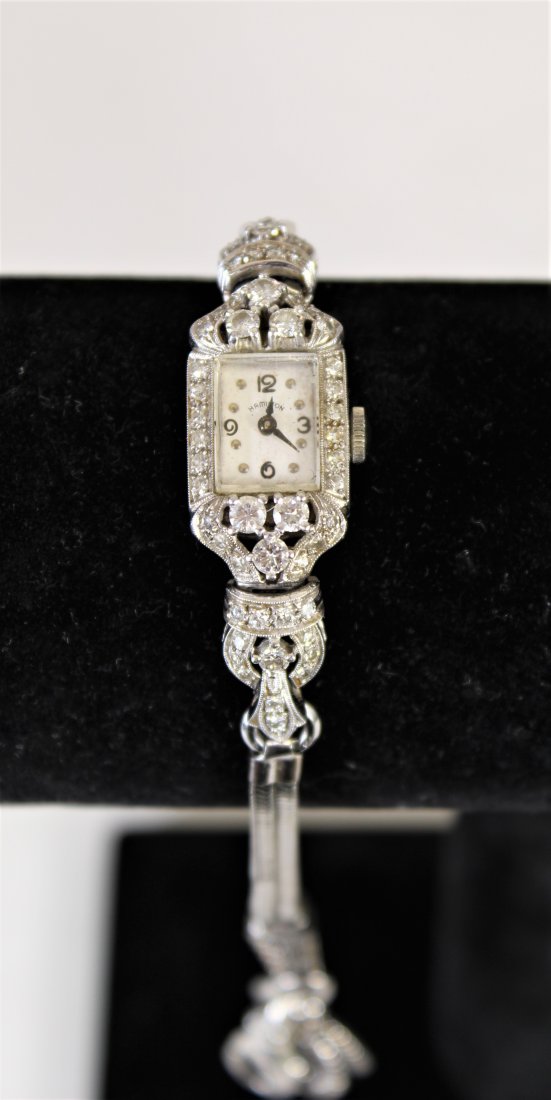 Ladies Hamilton Diamond & 12K White Gold Watch: Ladies Hamilton Diamond and 14k White Gold Watch. Weighs 28.6 grams. Marked on the latch. "Hamilton" is under the 12 on the face of the clock.