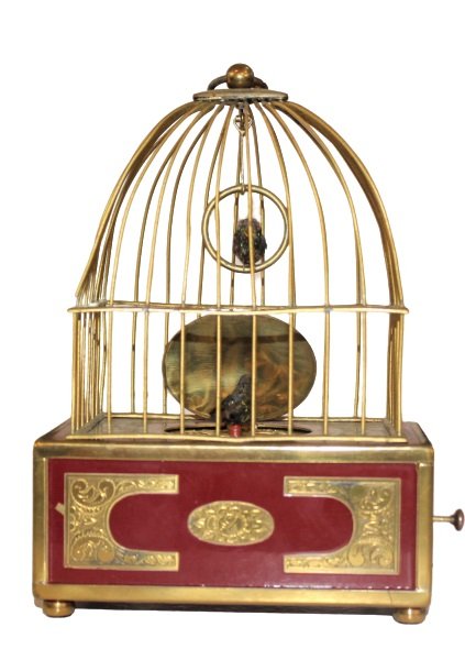 A Swiss Victorian Gilt Metal Singing Bird Cage: Very intricately engineered piece. Mechanical pieces are very fine and in working order. When triggered the bird comes out, twirls, sings, and then goes back into box. Approx 5 1/2 in tall. Please not