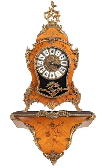 Hermle Bracket Clock, Louis XV Style: Inlaid Marquetry Case with Bronze Decoration.Movement has makers FHS mark and serial number. Clock: 12 x 5 3/4 x 22 1/2 in. Shelf: 14 x 7 x 9 in. Please note that all sales are final. No refunds will 
