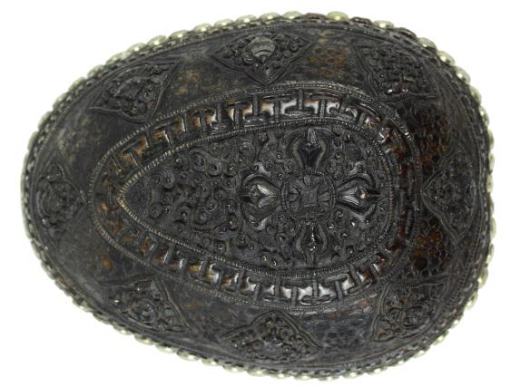 Tibetan Silver Ritual Skull Bowl: Tibetan carved and silver mounted skull bowl or Kapala, comprised of a Tibetan monk's skull with carved auspicious Buddhist symbols, lined with silver on the interior and trimmed with a band of silver