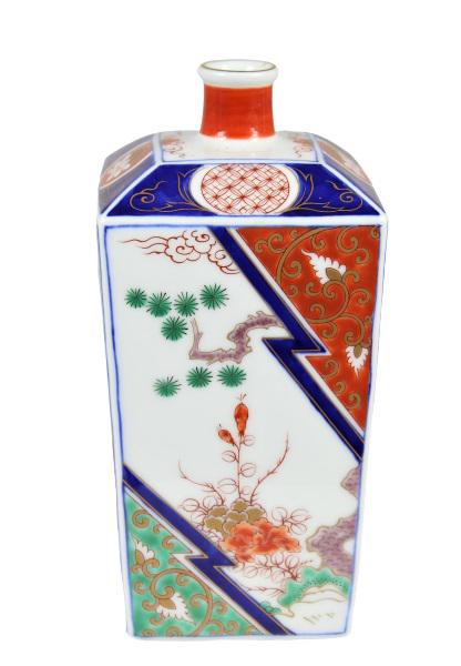 Japanese Imari Bottle Vase, Marked: Japanese Imari bottle vase with bright colors including red, yellow, green and blue. It has a Japanese marking on the underside, a square form shape with a bottle opening at the top. Appears to be in