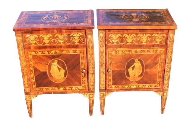 Pair of Antique Marquetry Nightstands: Beautiful nightstands with figure scenes on the front, opening cabinetry doors, tapered legs, commensurate with age. They are solid on their feet, wormwood damage on back is not active. Doors open and