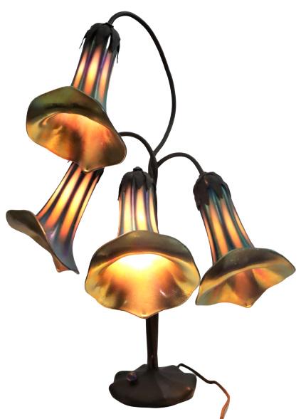 John Cook Studios Bronze Art Glass Lily Lamp: Lily lamp features four favrile art glass iridescent shades and a bronze twisted base. Signed and numbered on bottom of base: John Cook Studios 87 #4LL 209. As is.Size: 24 x 19 1/2 x 12 in. Please not