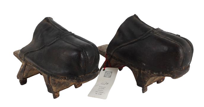 Pair of Manchu Leather Platform Shoes: Pair of Manchu Leather Platform ShoesThe multi-pieced stitched leather foot covering, atop a metal-mounted wood platformSize: 9 1/2 x 3 1/2 x 7 in.