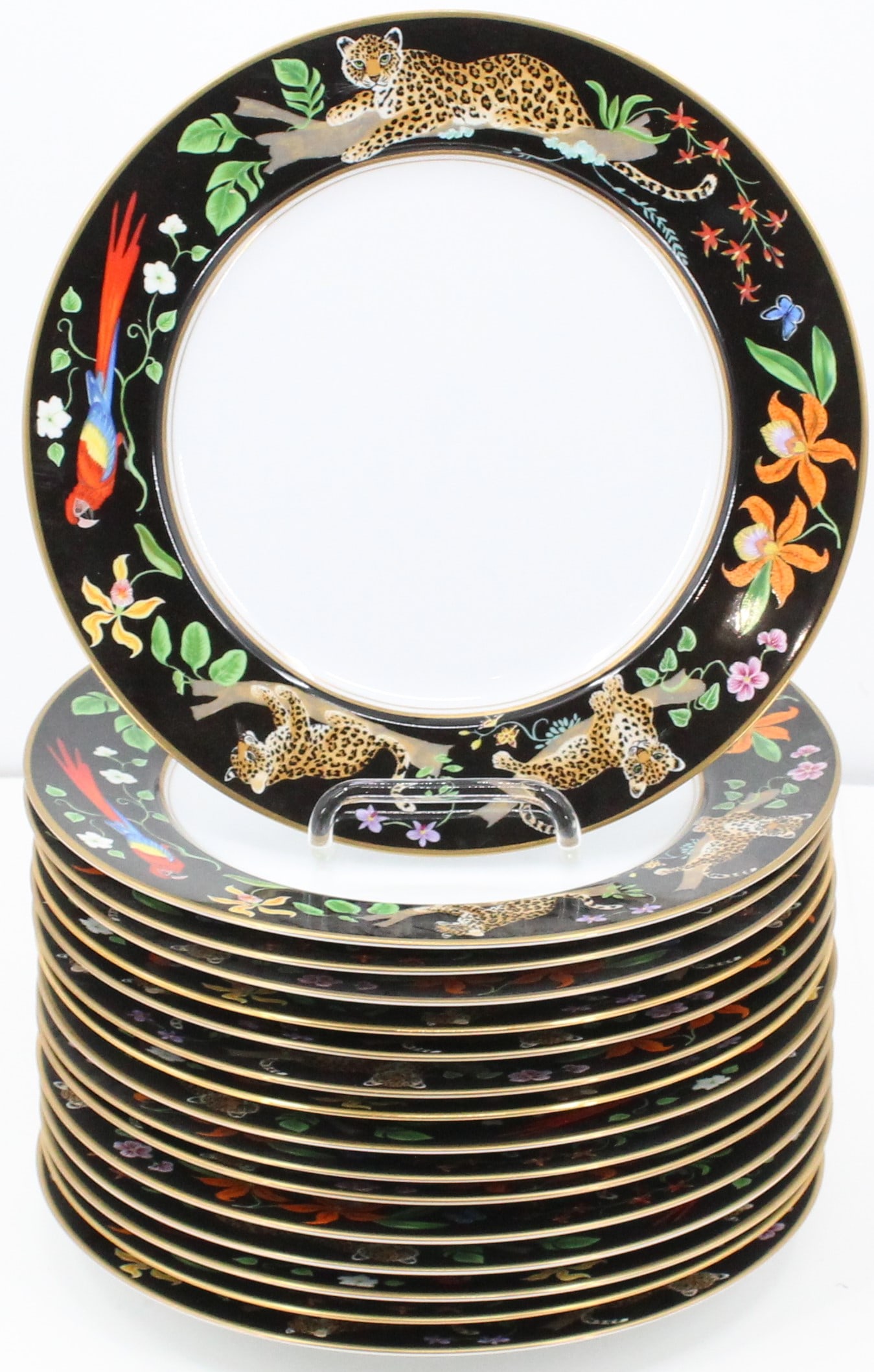 (16) Lynn Chase Jaguar Jungle Dinner Plates 11": An estate collection with 16 dinner plates by Lynn Chase Designs (American). Jaguar Jungle pattern, with jungle cats, parrot birds, and floral forms to rim. 24k gold gilt embellishments. Original art 