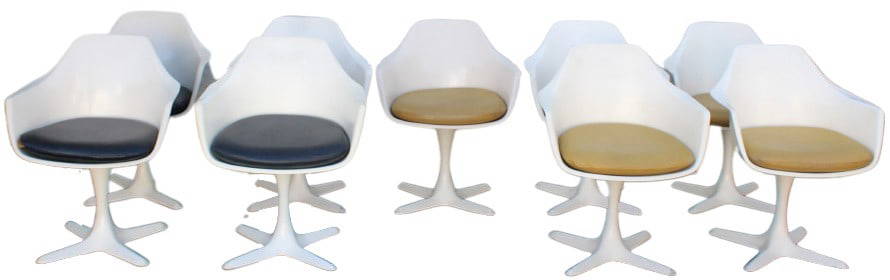 (9) Maurice Burke Tulip Chairs: (9) Maurice Burke Tulip Chairs. Tags on underside. Nine white swivel chairs. Sleek and modern design, with a white plastic shell. Chair rests on a white aluminum cross base. 6 with orange cushions. 3