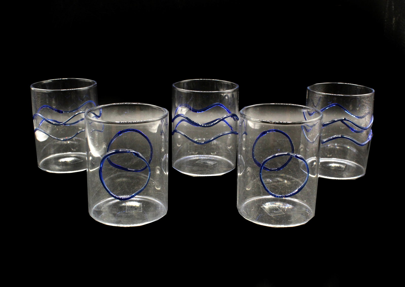 5 Ichendorf Milano Tumblers: 5 Ichendorf Milano Tumblers . All 5 have sticker on underside. Clear tumblers with blue drip design. 3 with 2 wavy lines. 2 with circles. Condition: Commensurate with age. 