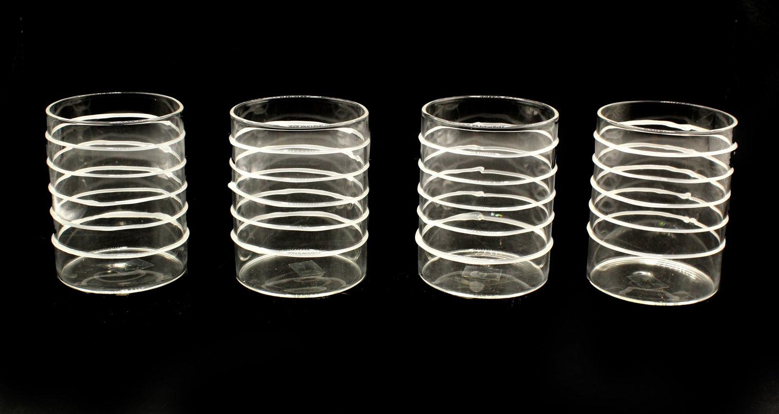 4 Ichendorf Milano Tumblers: 4 Ichendorf Milano Tumblers. All four have sticker on underside. Clear tumblers with white horizontal parallel drip design. Condition: Commensurate with age. Size: 2 3/4 x 2 3/4