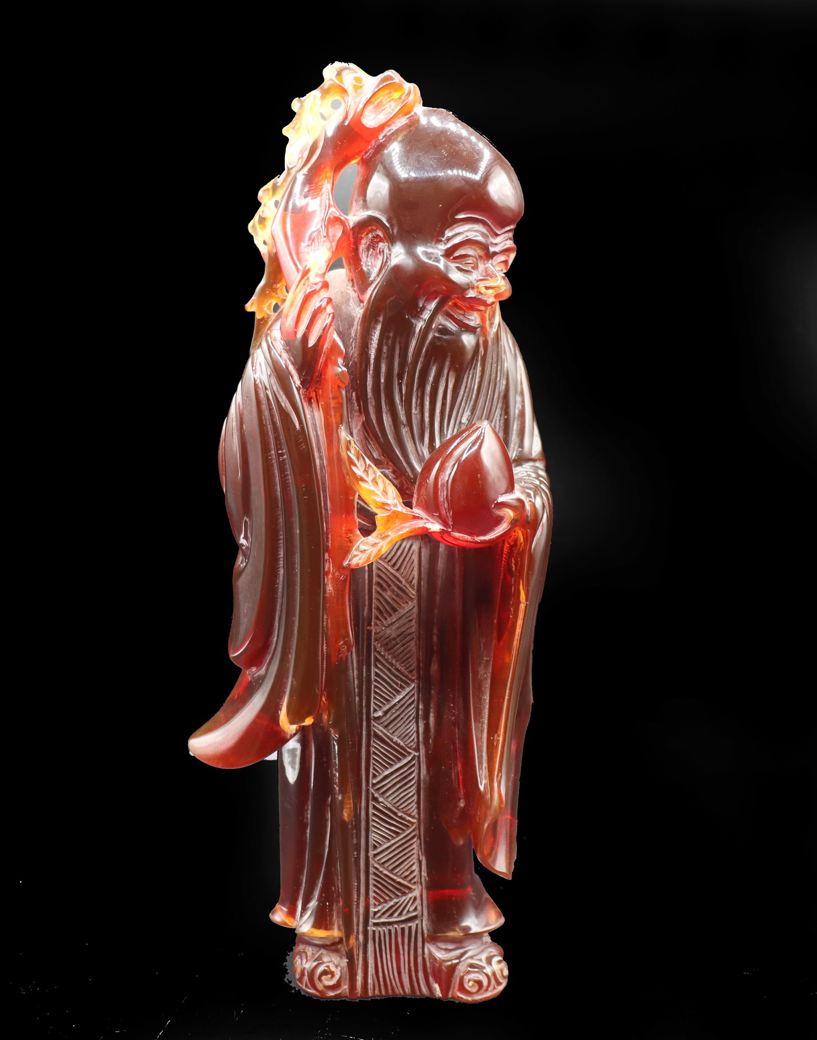 Chinese Amber Resin Shouxing Sculpture: Chinese Amber Resin Shouxing Sculpture. Classic depiction, holding a peach and a staff. Hole in the base for mounting. Size: 5 x 13 x 3 1/4 in. #8364 . Shouxing, also known as Shou L