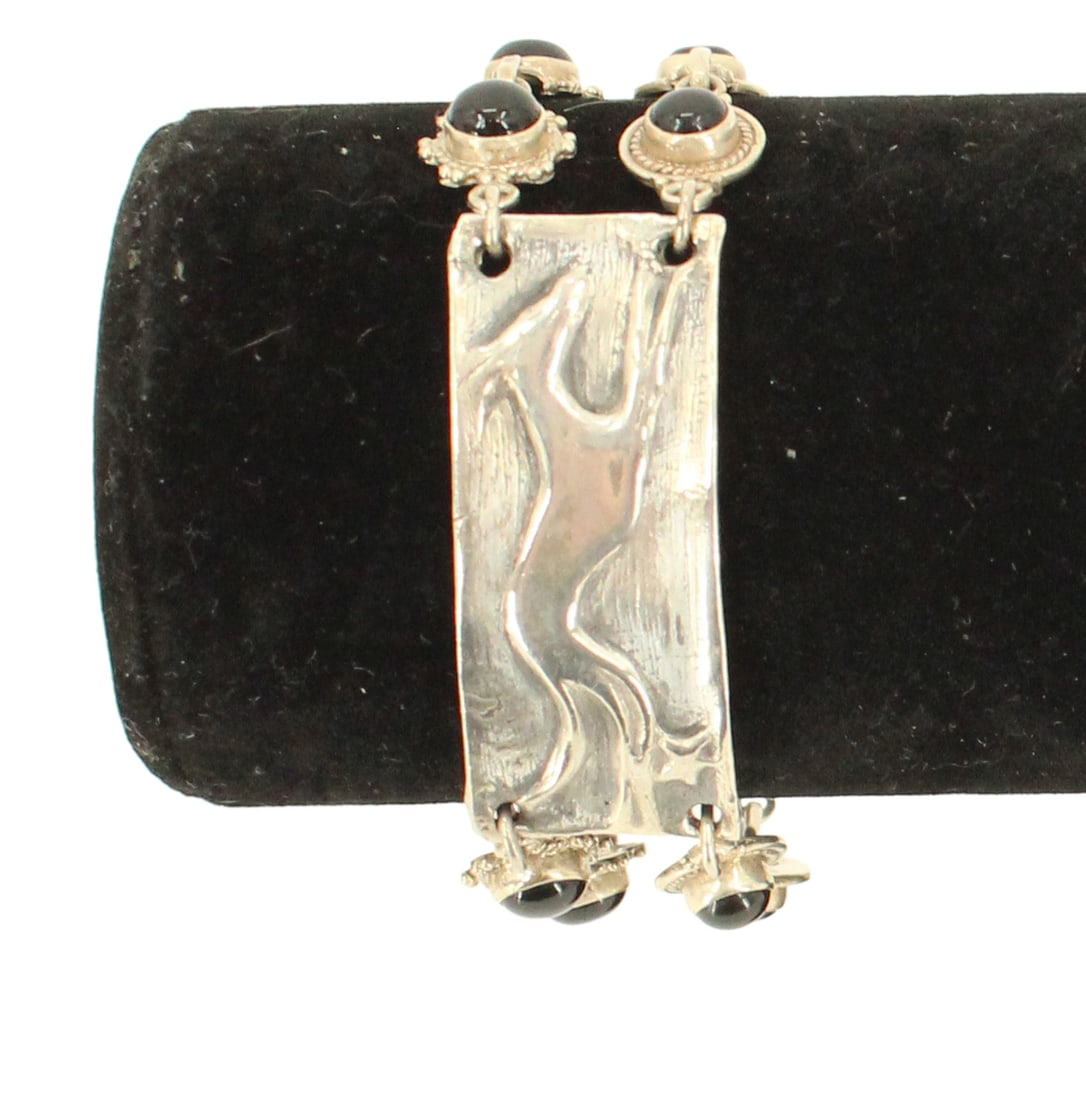 Silver Greyhound, Onyx and Blue Topaz Bracelet - Gross 1.0 ozt.: Silver Greyhound, Onyx and Blue Topaz Bracelet . Marked on back. Most prominent feature is a rectangular silver plaque with a stylized greyhound. Round cut onyx. Teardrop shaped blue topaz. 