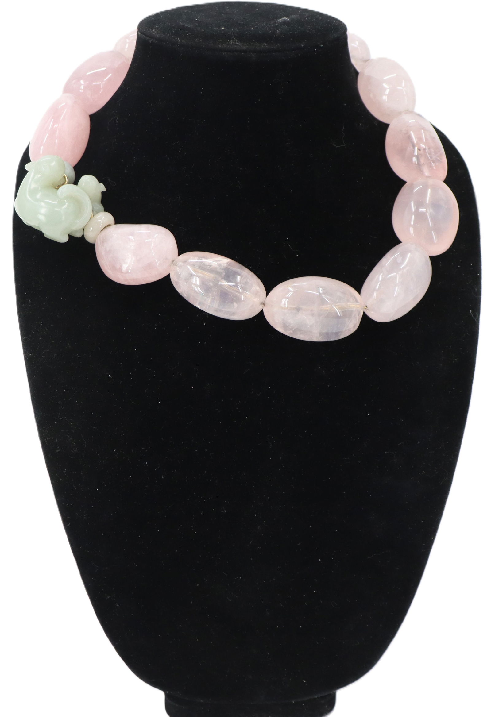 Pink Jadeite Necklace: Pink Jadeite Necklace. Oblong oval pink beads. Green carved jadeite pendant depicting a stylized animal. Length: 18 in. 