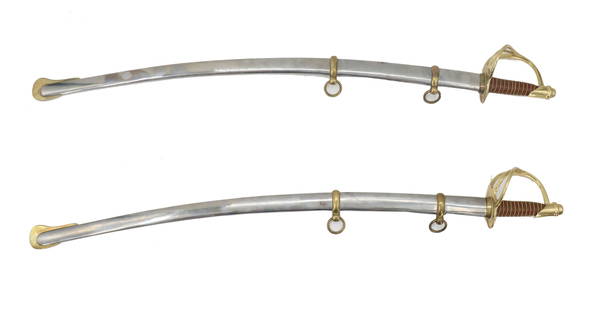 Pair of Cavarly Swords with Original Scabbards: Pair of Cavarly Swords with Original Scabbards. Two sabres with an elaborate d-guard design that sweeps down from the pommel to protect the hand. The scabbard matches the length and curve of the blade