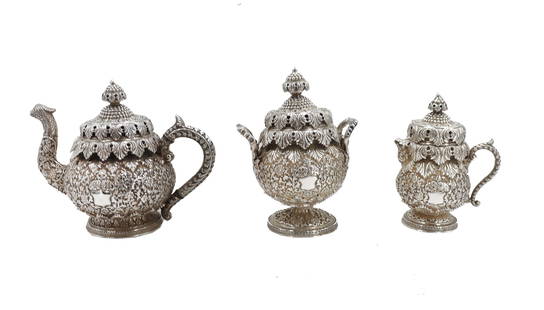 (3) Indian Ornate Sterling Silver Metal Tea Set: (3) Indian Ornate Silver Metal Tea Set. A beautiful and unique ornately decorated tea serving set of tea pot, creamer, and sugar bowl, with exterior decorated in highly detailed foliate metalwork with