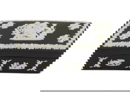 Wedgwood Black Jasperware Lidded Trinket Box: This elegant lidded trinket box is a fine example of English Wedgwood black jasperware, distinguished by its matte black ceramic body adorned with applied white classical reliefs. The lid features a n