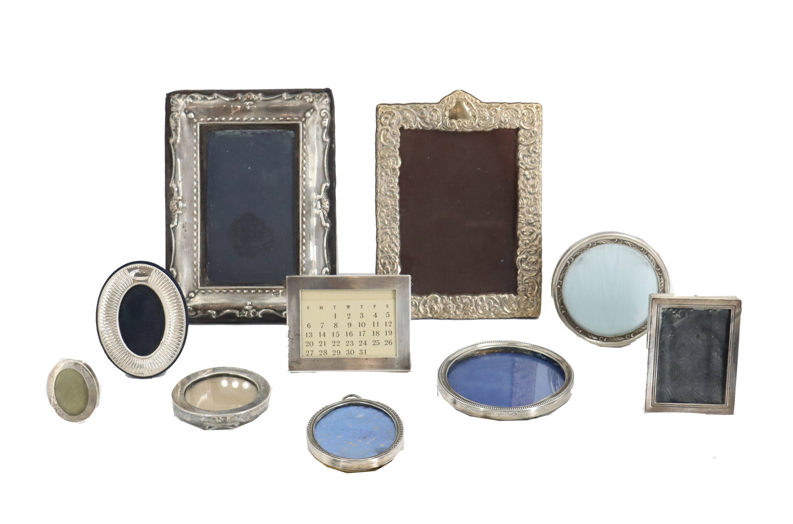 (10) Vintage American and European Sterling Silver Picture Frames: (10) Vintage American and European Sterling Silver Picture Frames. Includes 1 Tiffany & Co. calendar, 2 vertical frames with ornate designs, 6 diminutive round or oval frames, and 1 