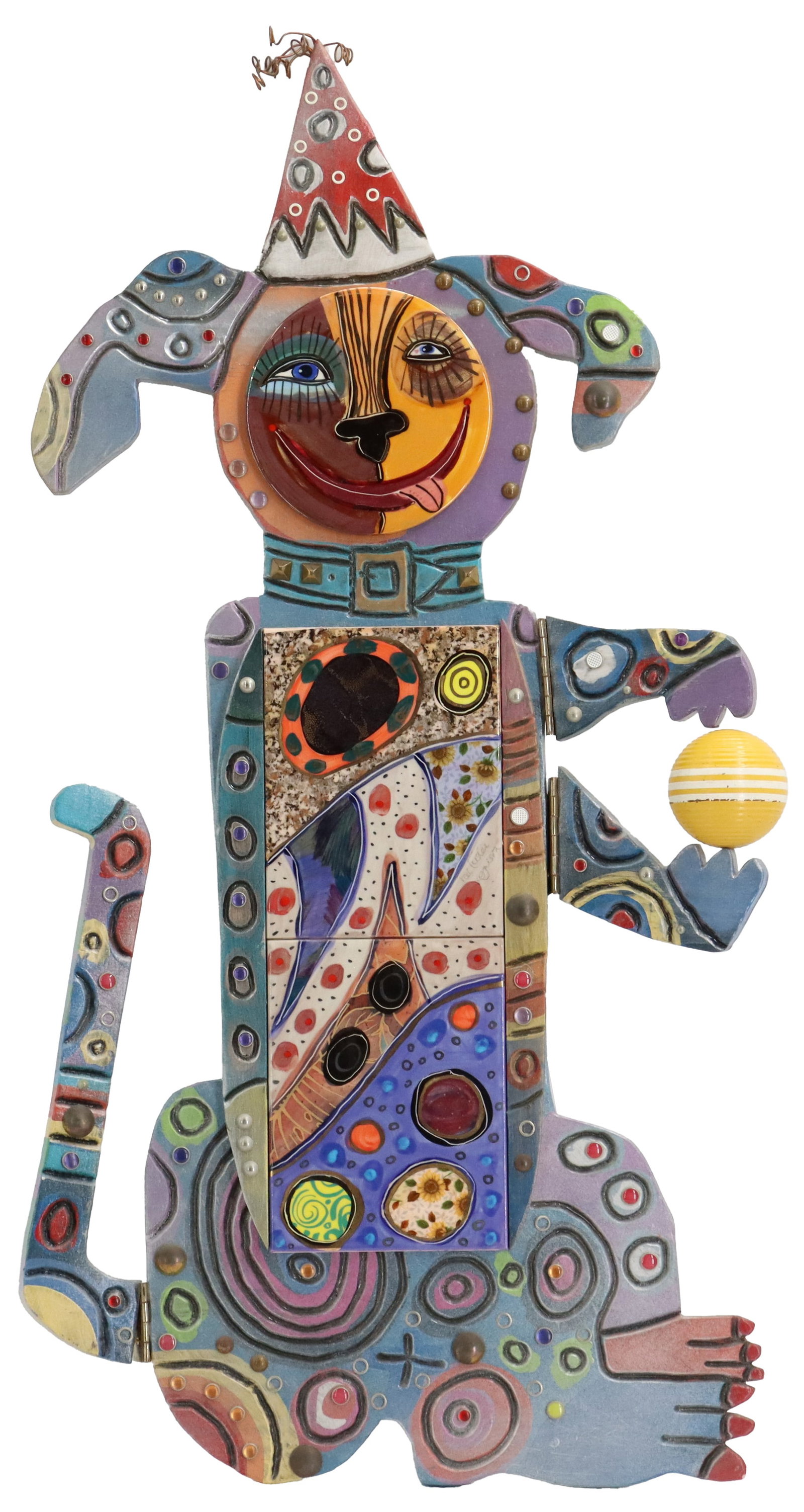 Pat Custer Denison (Born 1948) American, Mixed Media Whimsical Dog Sculpture: Pat Custer Denison (Born 1948) American, Mixed Media Whimsical Dog Sculpture. Incorporates ceramic tile, carved wood, and paint to depict a dog gleefully playing with a ball in a party hat. Signed on