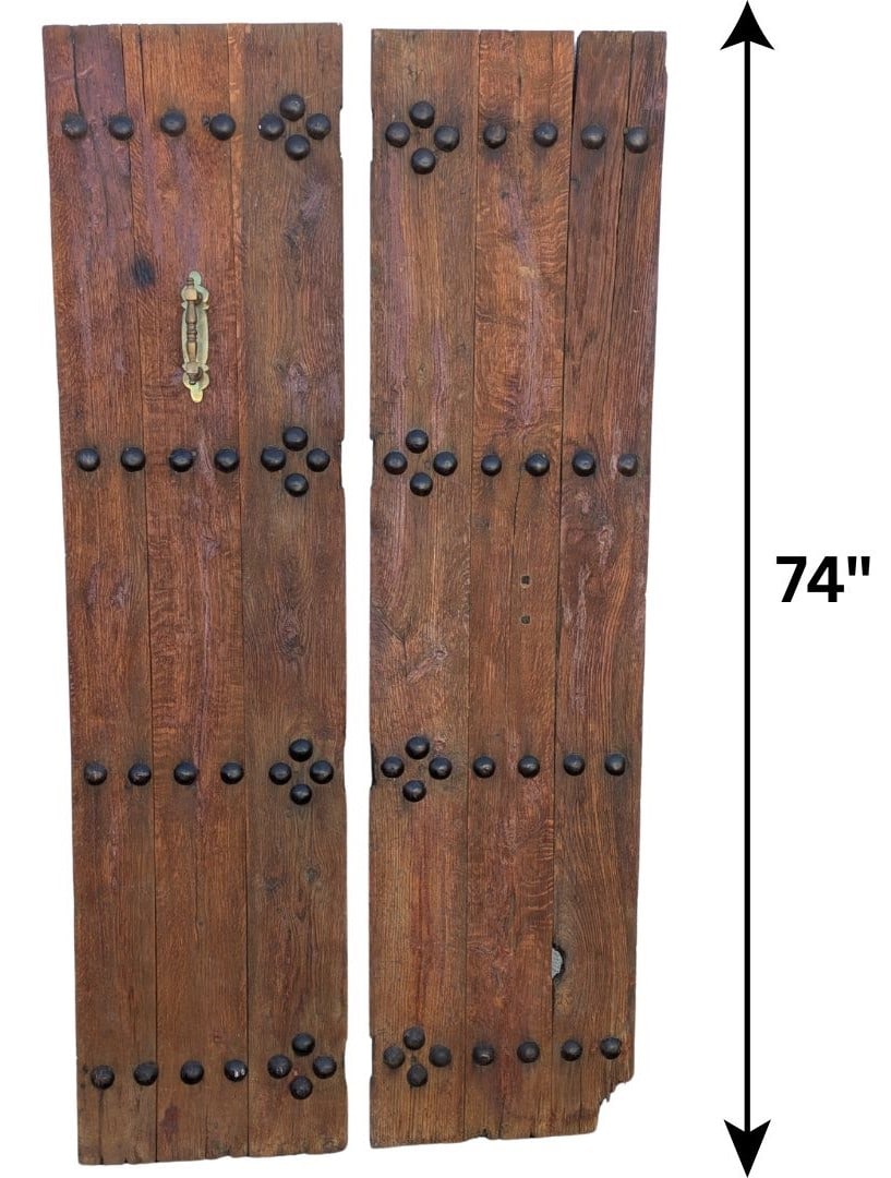 Pair of Old Kunati Teak Doors: Pair of Old Kunati Teak Doors. Numerous iron studs arranged symmetrically across them. Size: 74 1/2 x 19 Inches