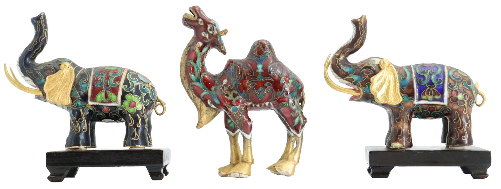 (3) Chinese Cloisonne Animals - Elephants and Camel: (3) Chinese Cloisonne Animals - Elephants and Camel. Pair of elephants with their trunks raised high. Each standing on a simple dark wood base. Both wearing a decorative saddle blanket. The camel is p