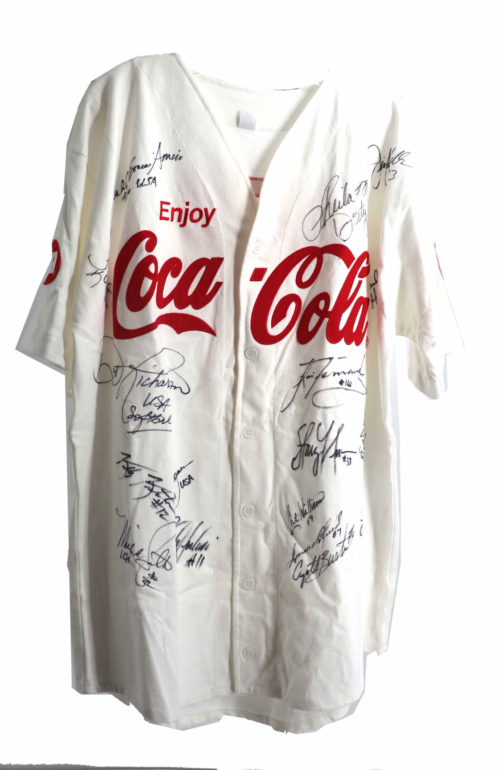 Coca-Cola 2004 Olympic Women's Softball Team Jersey: Coca-Cola 2004 Olympic Women's Softball Team Jersey. The front features a large graphic of a softball with the Coca-Cola and IGA (Independent Grocers Alliance) logos. The shirt is