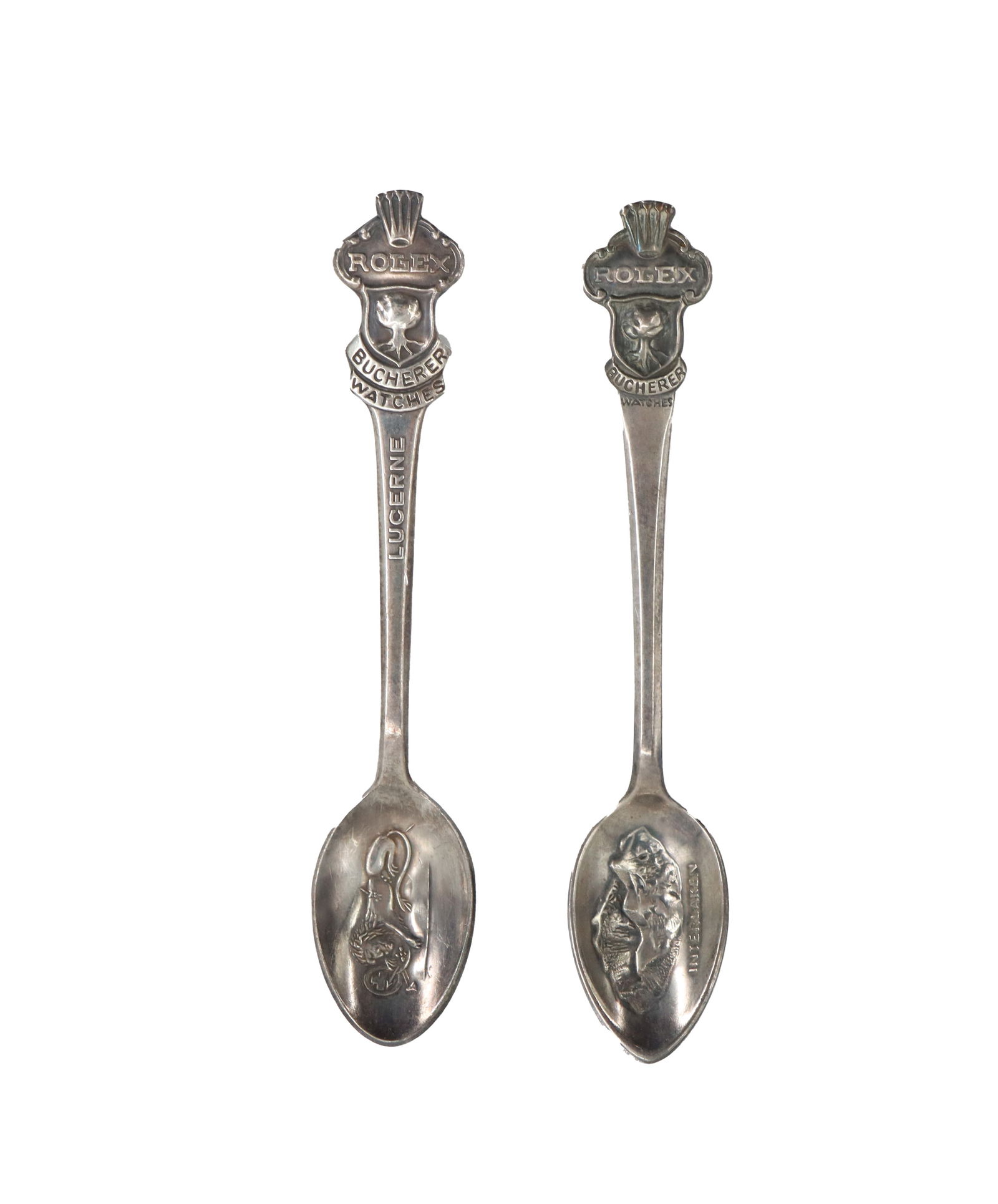 (2) Swiss Bucherer Rolex Silverplated Souvenir Spoons: (2) Swiss Bucherer Rolex Silverplated Souvenir Spoons. Each spoon is a unique offering, and are both marked on the back "B 100 12." This indicates that 100 grams of silver was used to plate