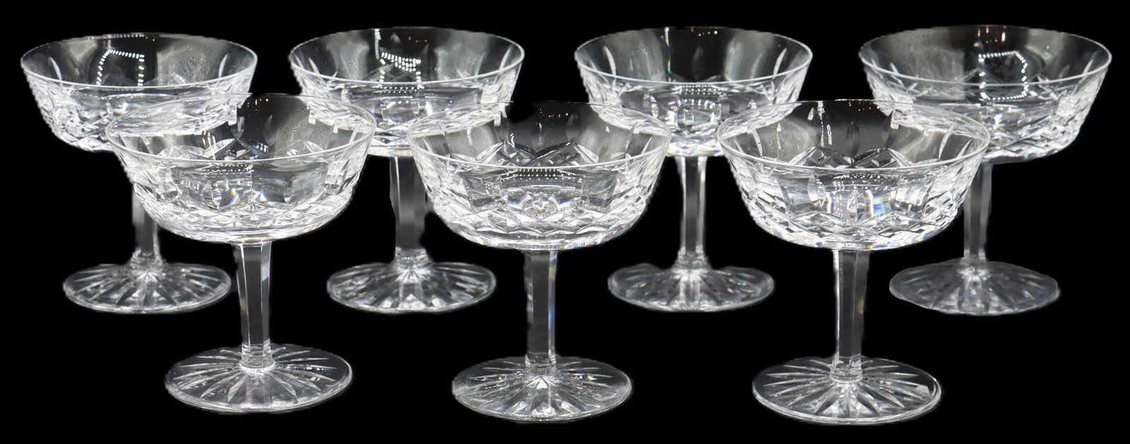(7) Waterford Crystal Lismore Champagne Glasses: (7) Waterford Crystal Lismore Champagne Glasses. Classic cut glass pattern. Marked on the underside of the feet. Size: 4 x 4 x 4 in. Waterford Crystal is a manufacturer of lead glass