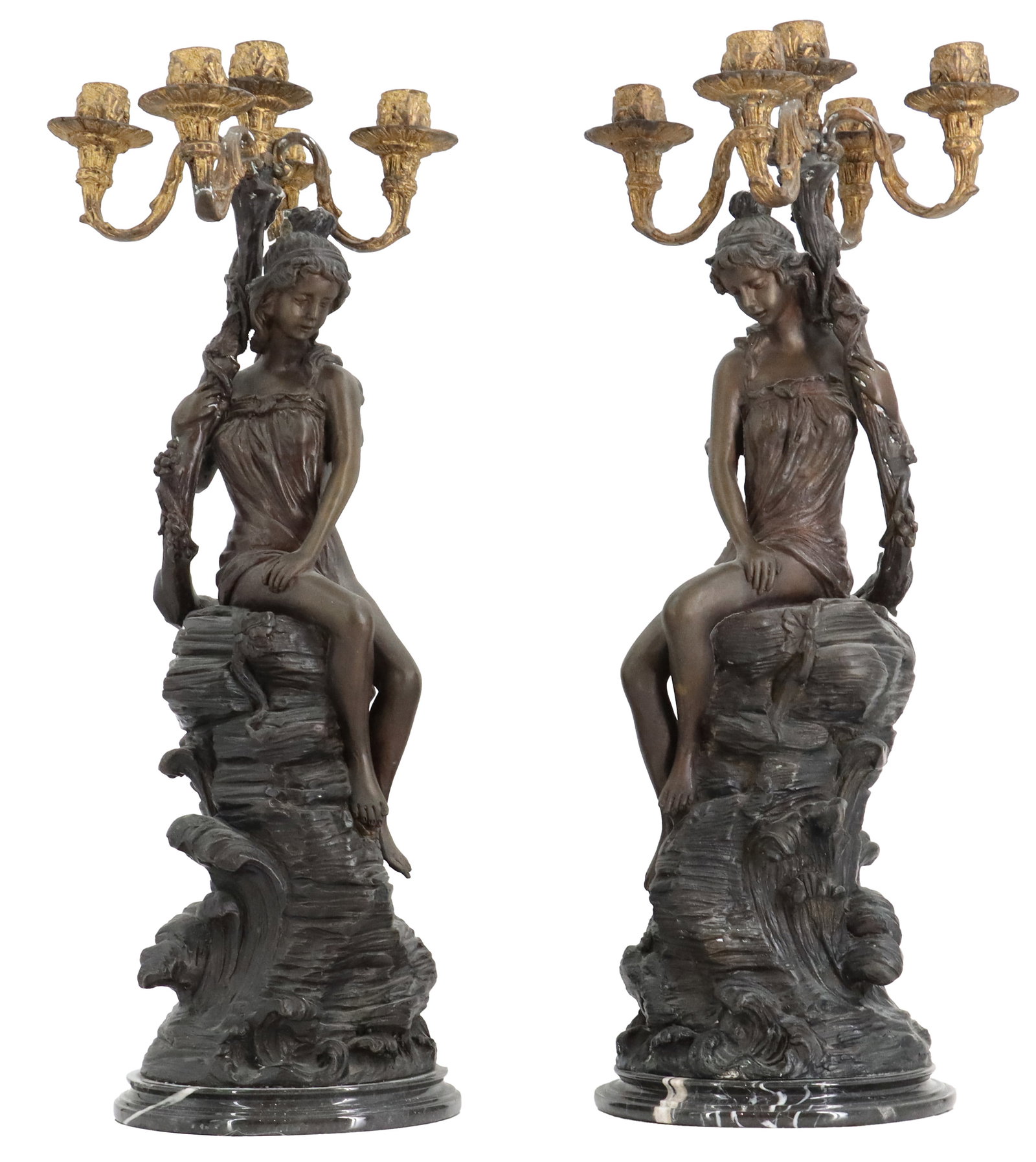 (2) Matched Bronze Finished Seated Goddess Candelabras: (2) Matched Bronze Finished Seated Goddess Candelabras. Pair of bronze-finished figural candelabras, each depicting a seated female figure atop a rocky, wave-like base supporting a four-light gilded s