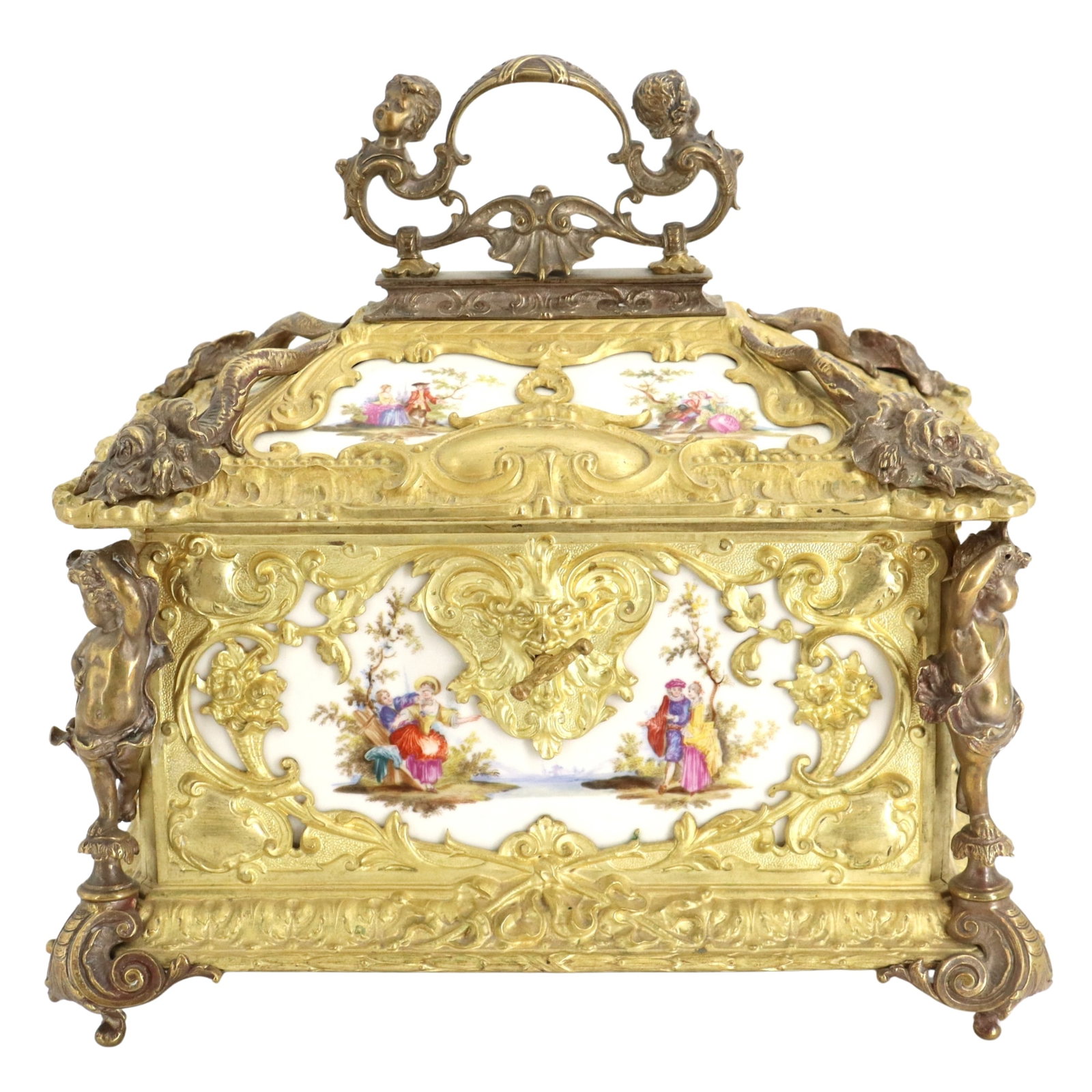 German KPM-Style Gilt Bronze Jewelry Box: German KPM-Style Gilt Bronze Jewelry Box. Ornate German casket or jewelry box featuring gilded metal scrollwork, figural cherub accents, and hand-painted porcelain panels depicting pastoral