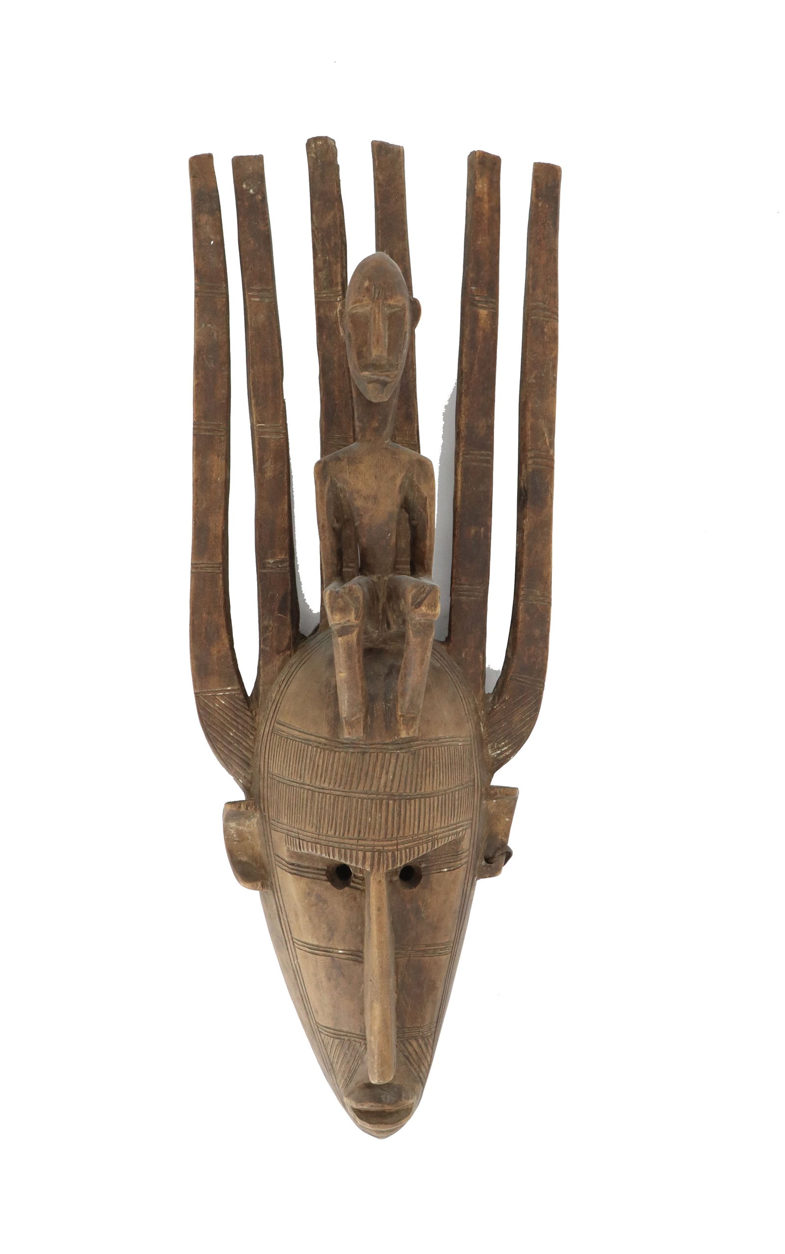 African Mali Carved Wood Bamana N'tomo Ceremonial Mask as Wall Art: African Mali Carved Wood Bamana N'tomo Ceremonial Mask as Wall Art. The mask has six horns, an earring in one ear, an elongated nose and pointed chin, and a small bald figure sitting on the d