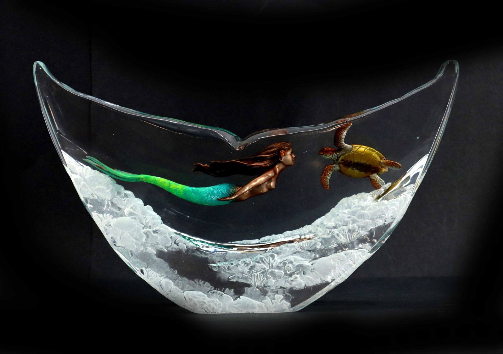 Robert Wyland (Born 1956) American, Glass Sculpture of Mermaid and Turtle: Robert Wyland (Born 1956) American, Glass Sculpture of Mermaid and Turtle. Crescent-shaped glass sculpture shaped like a whale's tail, featuring an internal aquatic scene with a bronze-toned 
