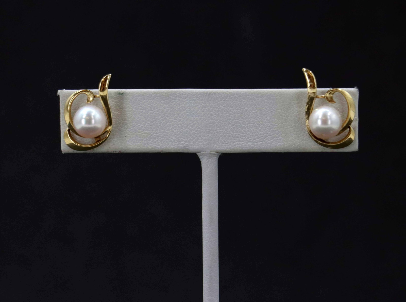 14k Yellow Gold and Pearl Stud Earrings - Gross 3.0 g.: 14k Yellow Gold and Pearl Stud Earrings - Gross 3.0 g. Elegant 14k gold stud earrings feature a central cultured pearl cradled within a polished, swirling ribbon setting that creates a graceful,