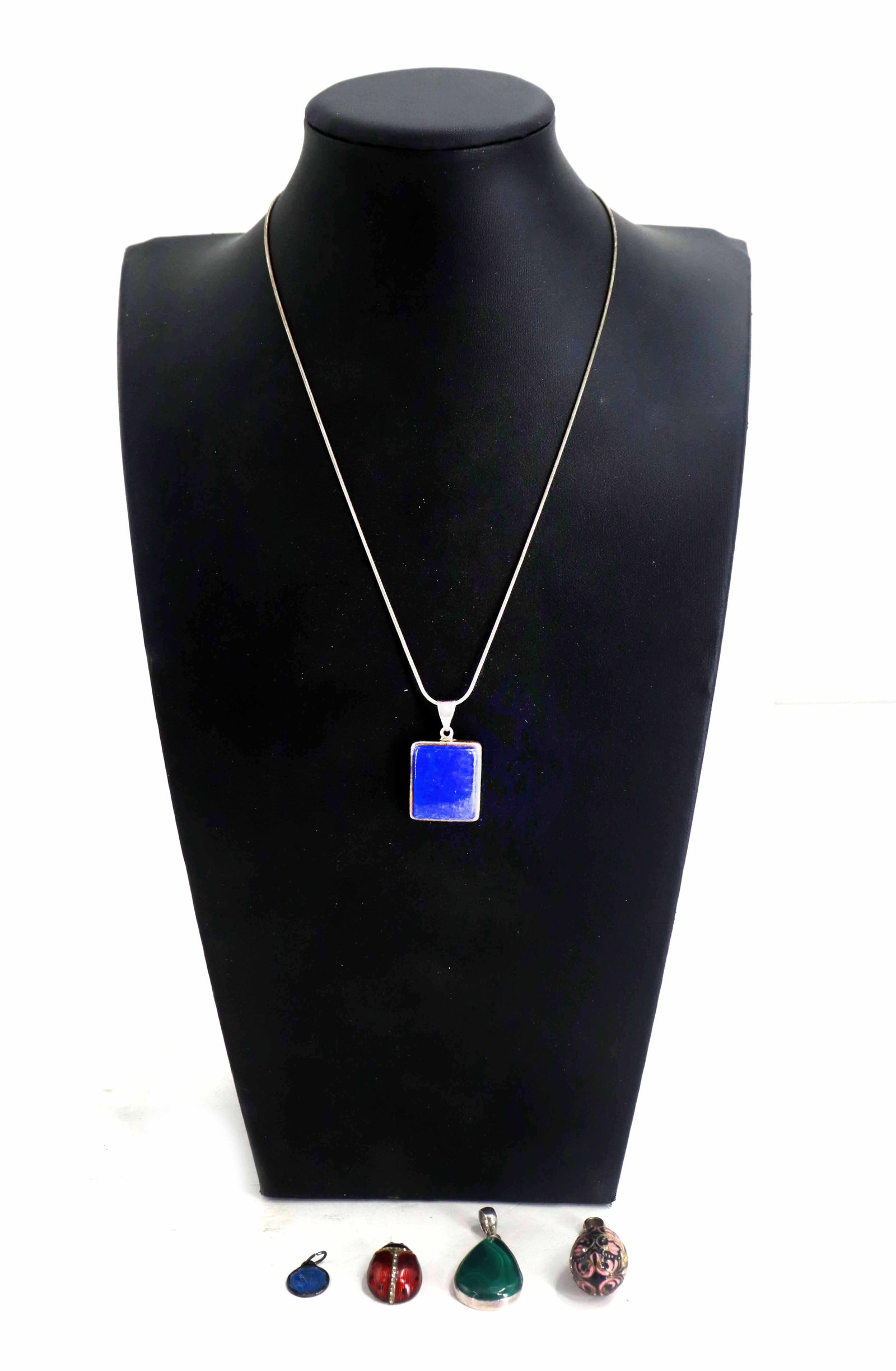 Sterling Chain and (5) Various Stone Pendants - Gross 1.140 ozt..: Sterling Chain and (5) Various Stone Pendants - Gross 1.140 ozt.. Lot comprised of a sterling silver chain and several loose pendants, including a small blue religious medal, a red and blac