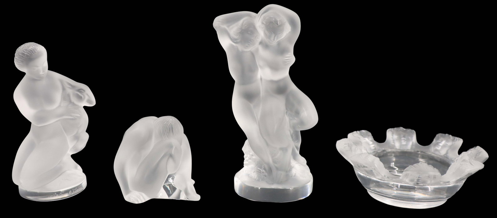 (4) Lalique Crystal Items: (4) Lalique Crystal Items . Includes 1 trinket dish and 3 nude figural sculptures. All marked or labeled on the undersides. Largest Size: 1 1/2 x 2 1/2 x 5 1/2 in. Lalique is a French