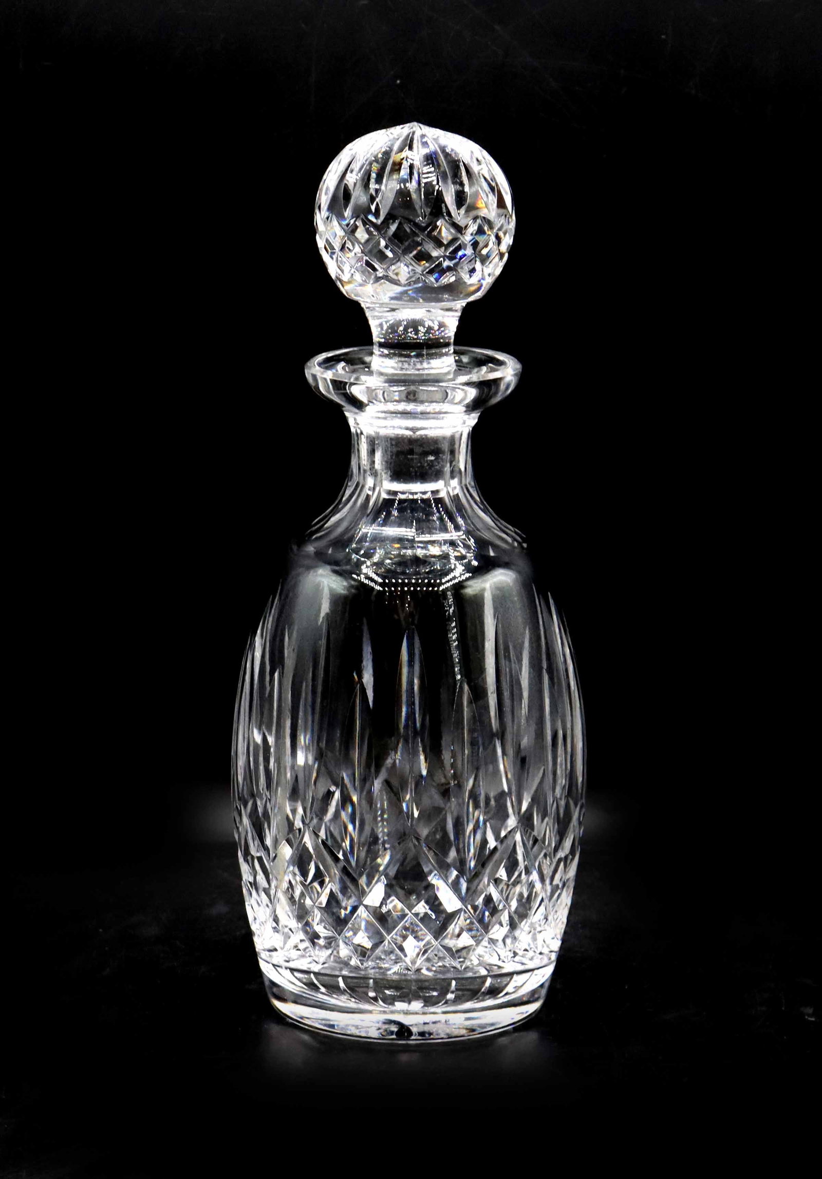 Waterford Crystal Lismore Spirit Decanter: Waterford Crystal Lismore Spirit Decanter. Elegant vintage cut crystal decanter featuring a tapered body with a deep crisscross diamond pattern and vertical wedge cuts, topped with a matching multifac
