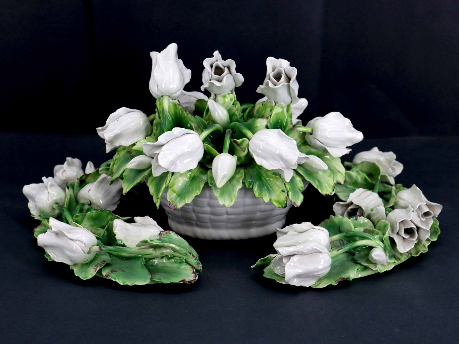 (3) Piece Capodimonte Style Porcelain Floral Centerpiece Sculpture: (3) Piece Capodimonte Style Porcelain Floral Centerpiece Sculpture. Comprised of a basket full of green leaves and white tulips and two moon-shaped green leaf accompaniments that are covered with the