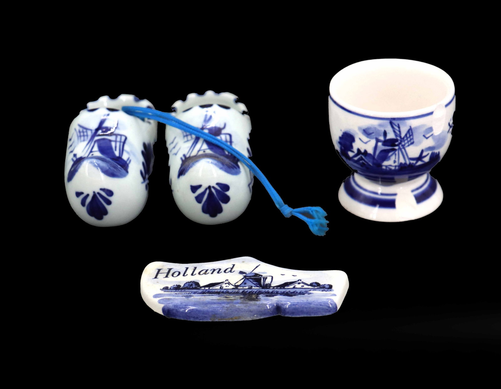 (4) Delftware Blue and White Porcelain Decorative Objects: (4) Delftware Blue and White Porcelain Decorative Objects. Includes two matching clogs attached to each other with a blue string, a wall art clog painted with the traditional image of a windmill 