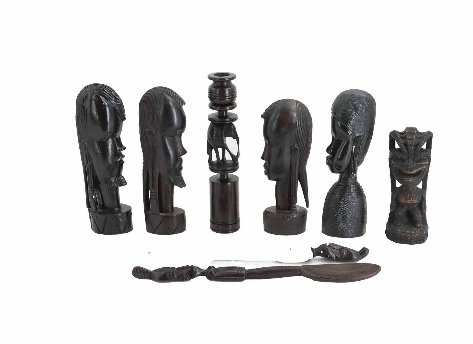 (8) Hawaiian and African Folk Art Carved Ebonized Wood Items: (8) Hawaiian and African Folk Art Carved Ebonized Wood Items. Stylized thin heads make up the busts, while a grinning totem with the word "Hawaii" carved at its feet, a candlestick with an e