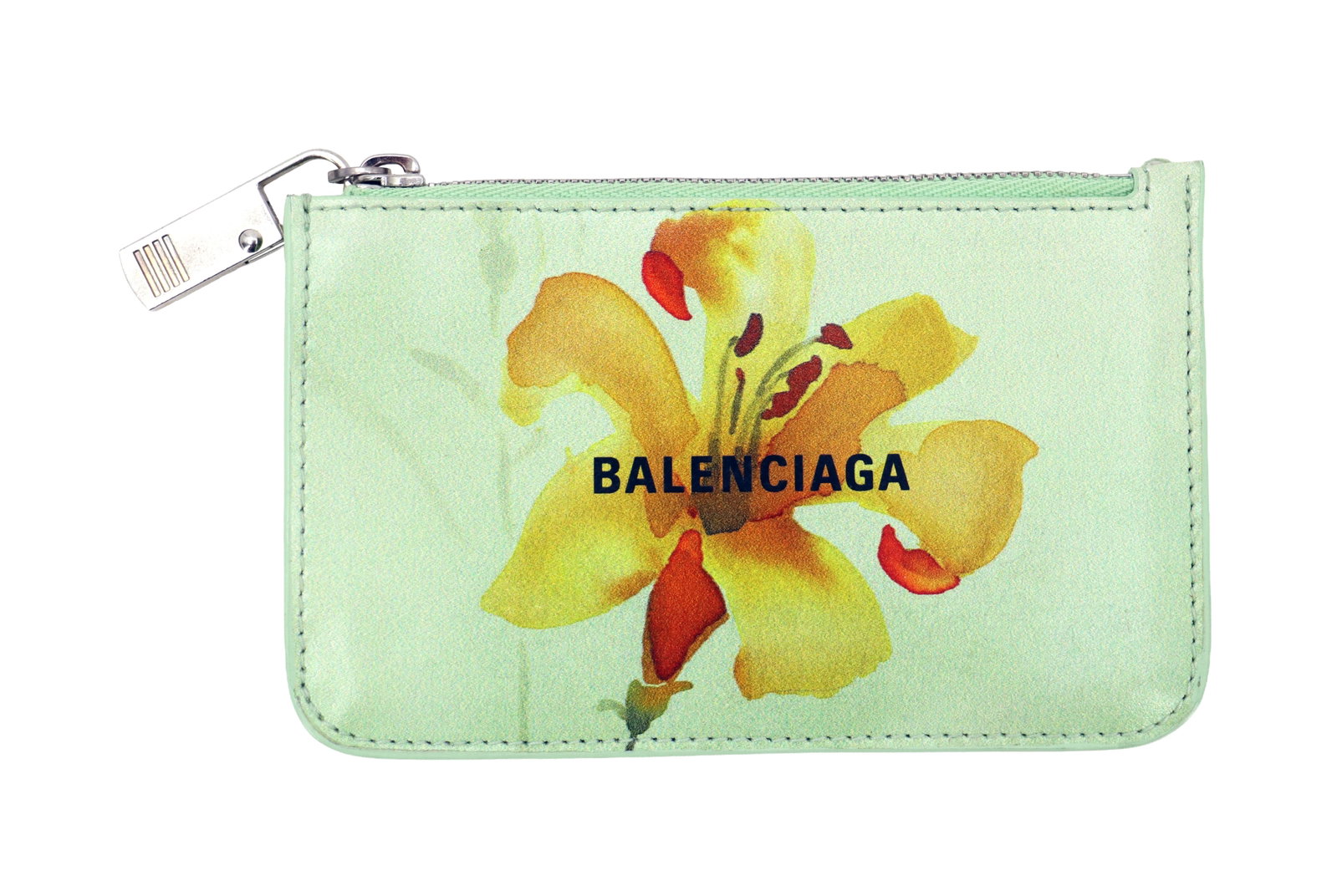 Balenciaga Coin Purse in Original Box and Dustbag: Balenciaga Coin Purse in Original Box and Dustbag. The name of the company is across the front, over an image of a red, yellow, and orange flower on a green background. Both the box and the dustbag be