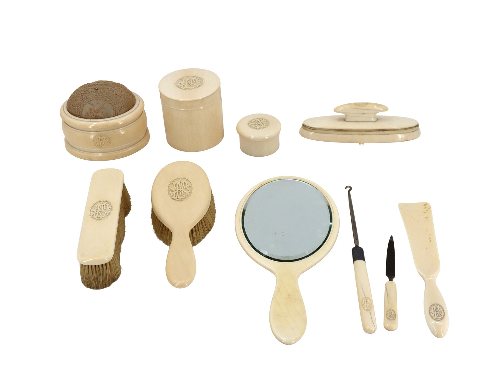(10) Piece Antique Celluloid Dressing Table and Vanity Set: (10) Piece Antique Celluloid Dressing Table and Vanity Set. Includes a hand mirror, 2 brushes, pin cushion, vanity containers, nail buffer and grooming implements. Largest Size: 12 x 6 in.