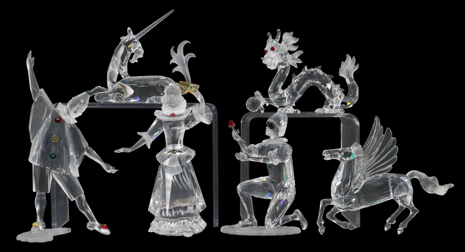 (6) Swarovski Crystal Figurines in Original Packaging: (6) Swarovski Crystal Figurines in Original Packaging. Six clear Swarovski crystal figurines—including three commedia dell'arte masquerade characters, a Chinese dragon, a winged Pegasus,