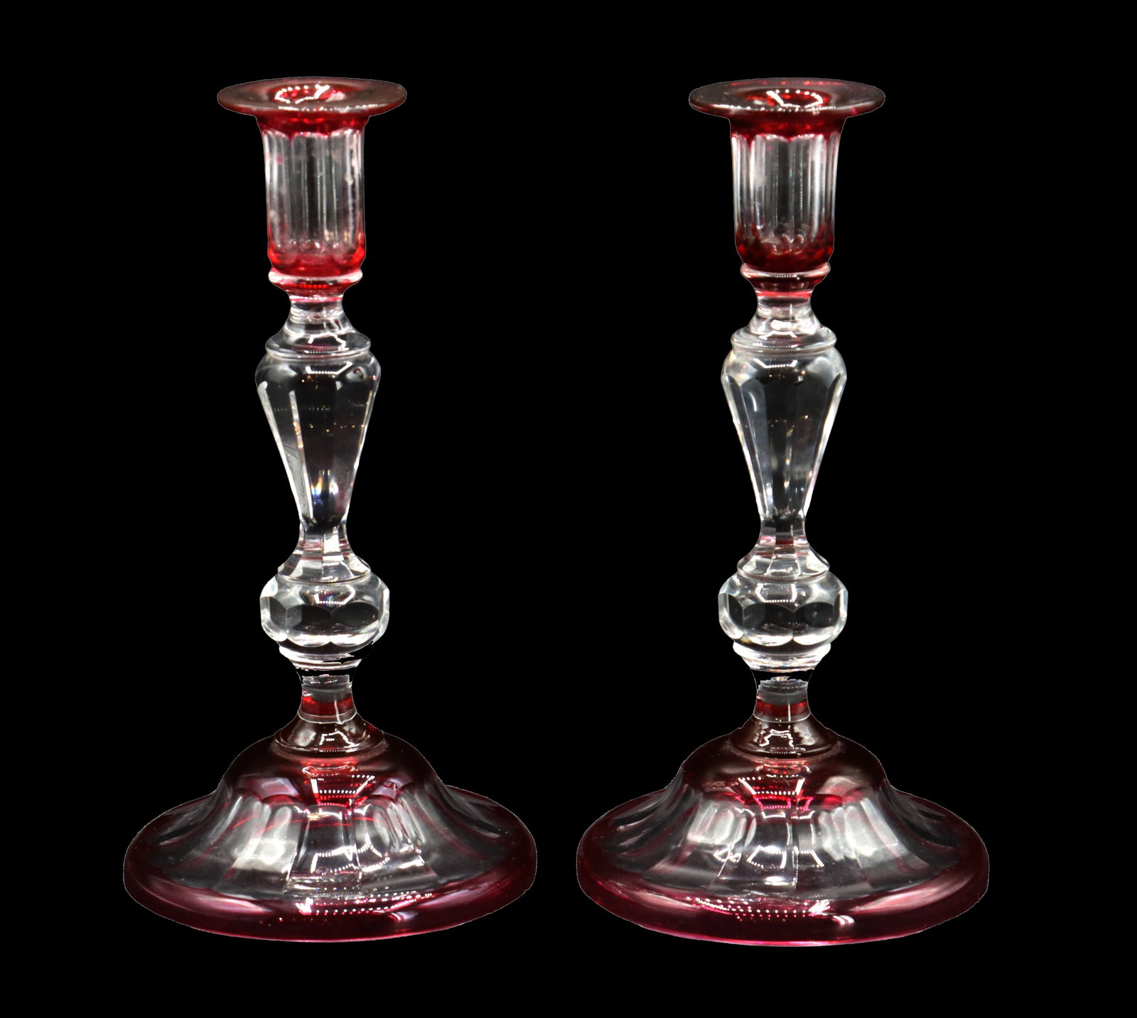 Pair of Red Cut-to-Clear Crystal Candlesticks: Pair of Red Cut-to-Clear Crystal Candlesticks. Though unmarked, they are good quality, in a style reminiscent of early Steuben with a baluster-style stem design. Condition: Fleabite on one foot.