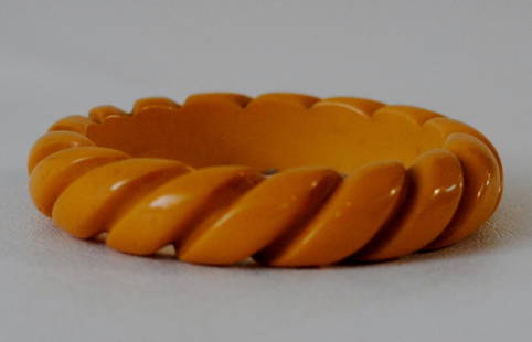 Yellow Bakelite Bangle w/ Curving Striped Motif: Yellow Bakelite bangle with carved detailing in a curving striped motif