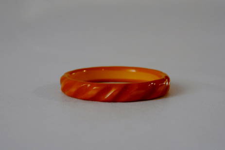 Yellow Bakelite Bangle w/ Curved Striped Motif: Yellow Bakelite bangle with carved detailing depicting a curved striped motif