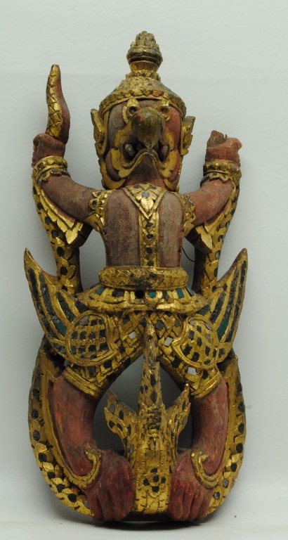 Antique Thai Buddhist Garuda Figure: Antique Thai Buddhist figure of Garuda in wood construction. Body having red paint with gilt painted accents. Also having inlaid colored glass. Figure is seen having snake in hands and talons. Height: