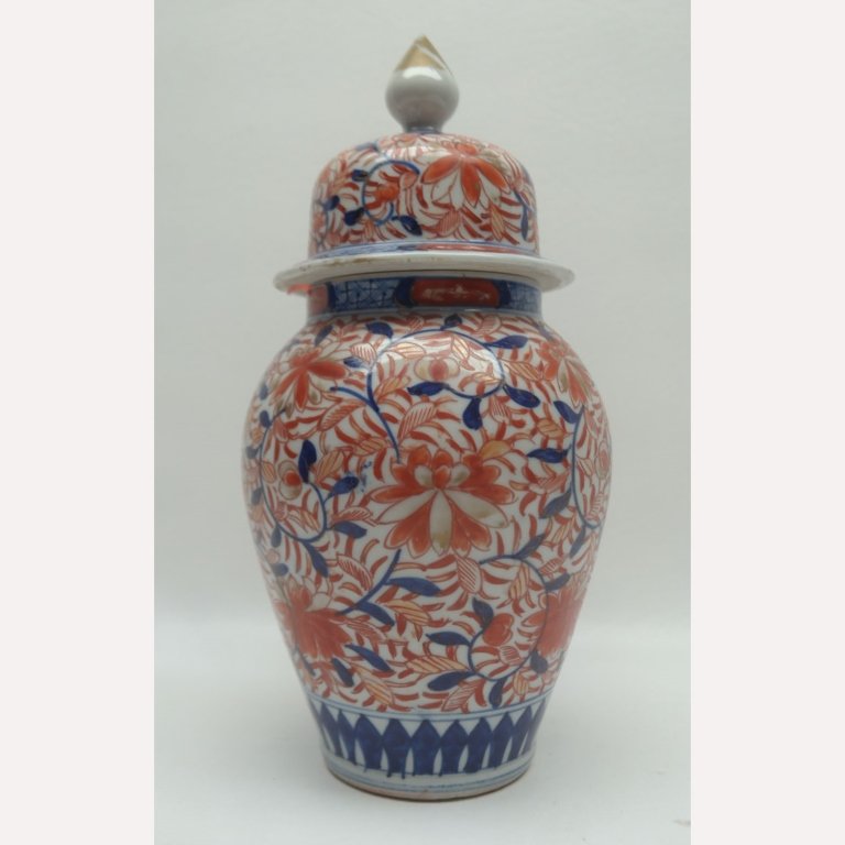 Antique Meiji Period Japanese Imari Covered Vase: Antique Meiji period Imari covered vase having floral motif of stylized lotus blossoms. Also having gilt finial. Height: 12 in. Condition: Loss to gilt on finial