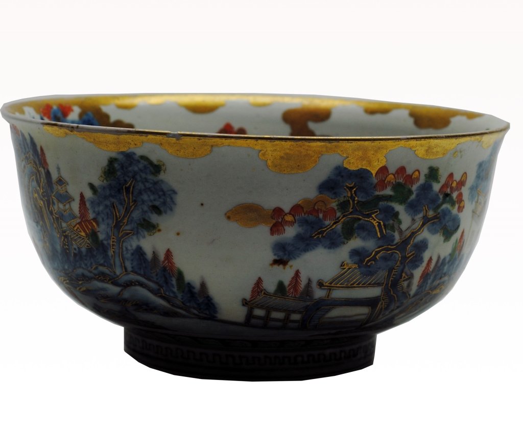 Antique Imari Bowl: Antique Imari bowl having central figure imagery of a five claw dragon in gilt. Also having architectural elements and stylized pine trees. Height: 5 in Diameter: 9.75 in