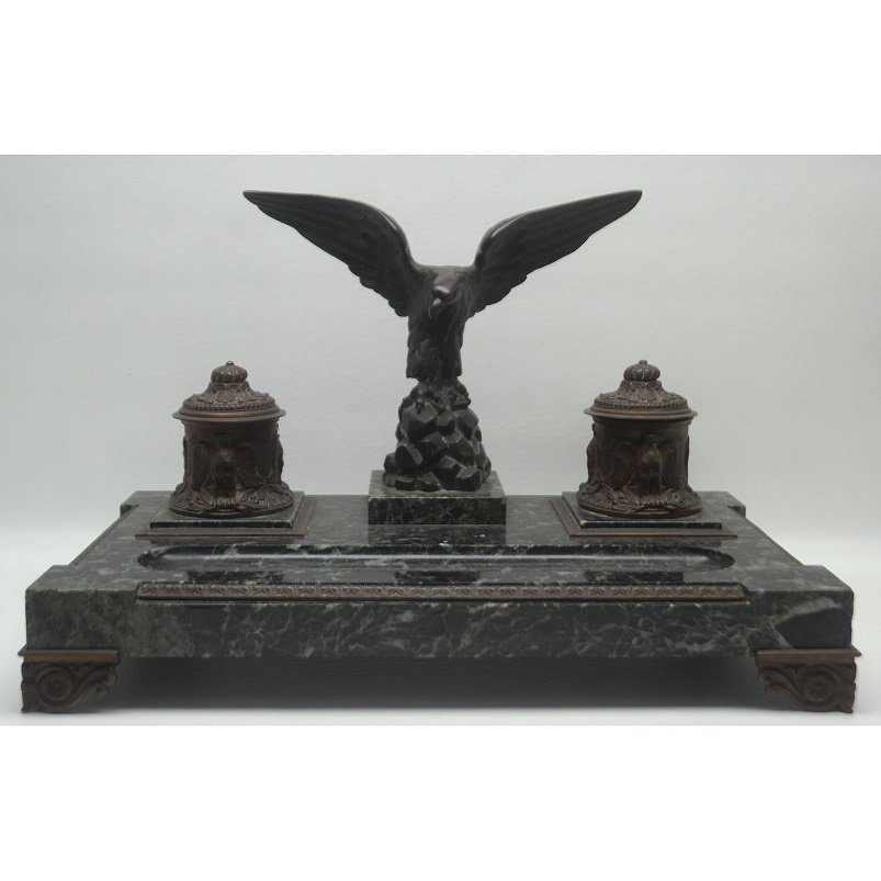 Bronze and Marble Desktop Inkwell: Antique bronze and marble desktop inkwell having decoration of an eagle perched atop rocks. With two inkwells set into a marble base. Signed "Van Dael". Height: 11 inches. Width: 17.5 inches