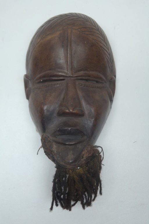 Antique Dan Mask: Antique West African Dan tribe mask in wood construction. Having carved slit eyes with beard constructed of old cloth and fiber. The Dan tribe occupies the Western part of Cote de Ivoire and Liberia.