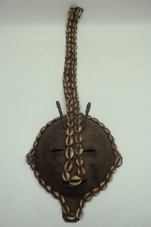 Antique African Mask: Antique African mask in leather and metal construction. Having cowry shell detailing.